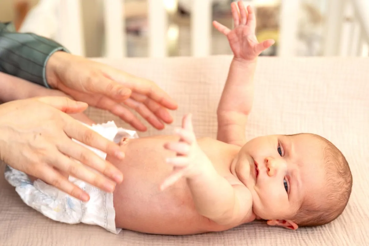 صورة لأم تغير حفاض مولودها