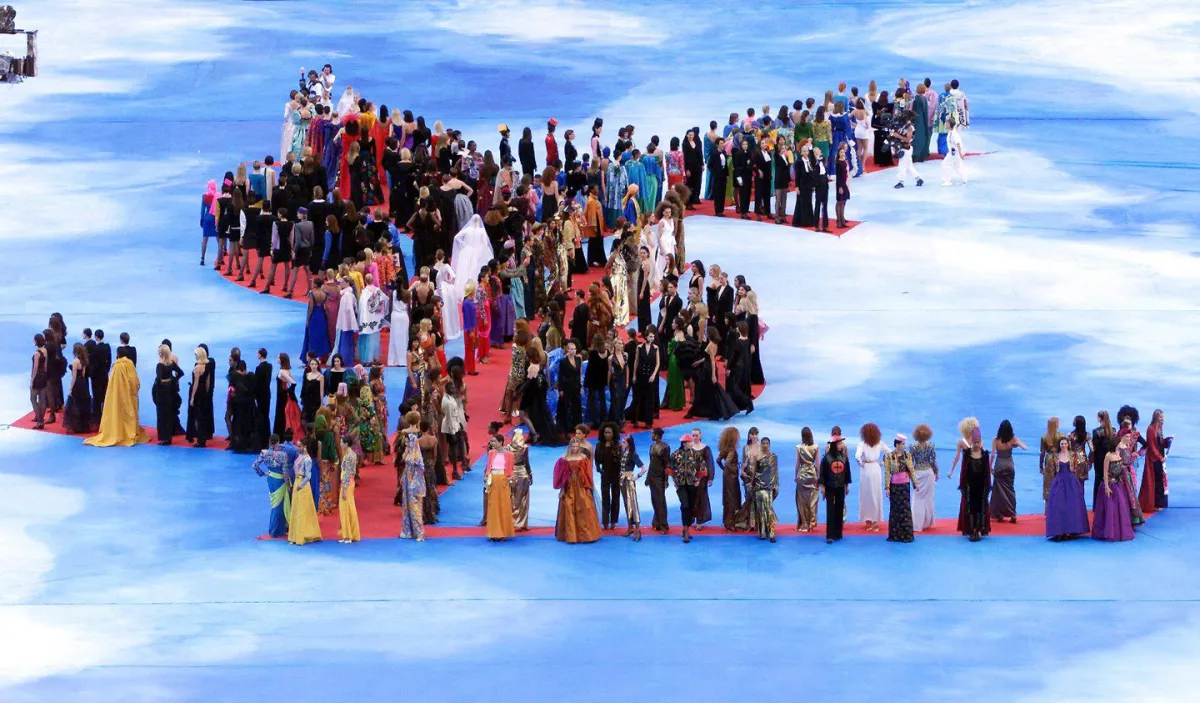 مشهد استعراضي مع لوغو إيف سان لوران Yves Saint-Laurent، قبيل نهائي بطولة العالم لكرة القدم في باريس، عام 1998، ما بين منتخبَي البرازيل وفرنسا (Thomas Coex/AFP via Getty Images).