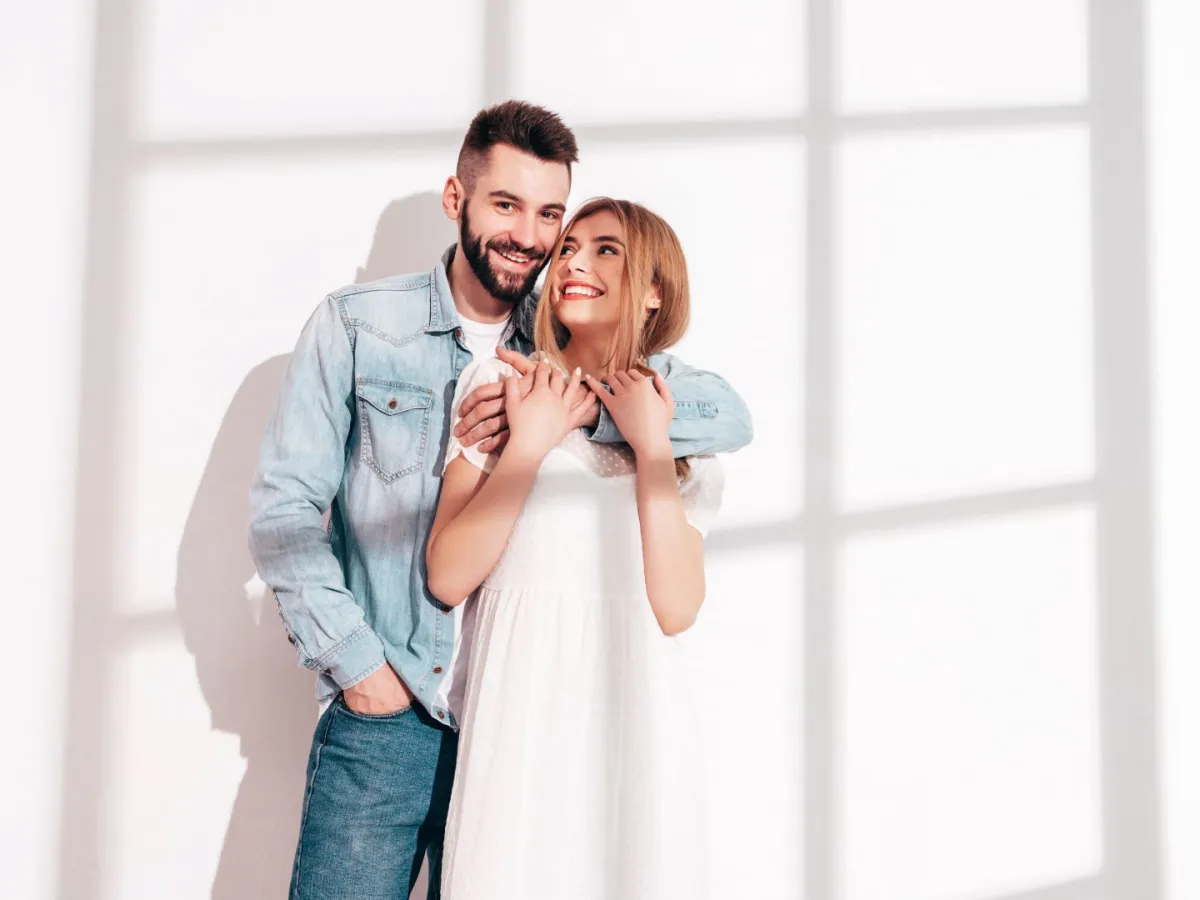 زوج يحتضن ظهر زوجته وهي تضحك بسعادة   