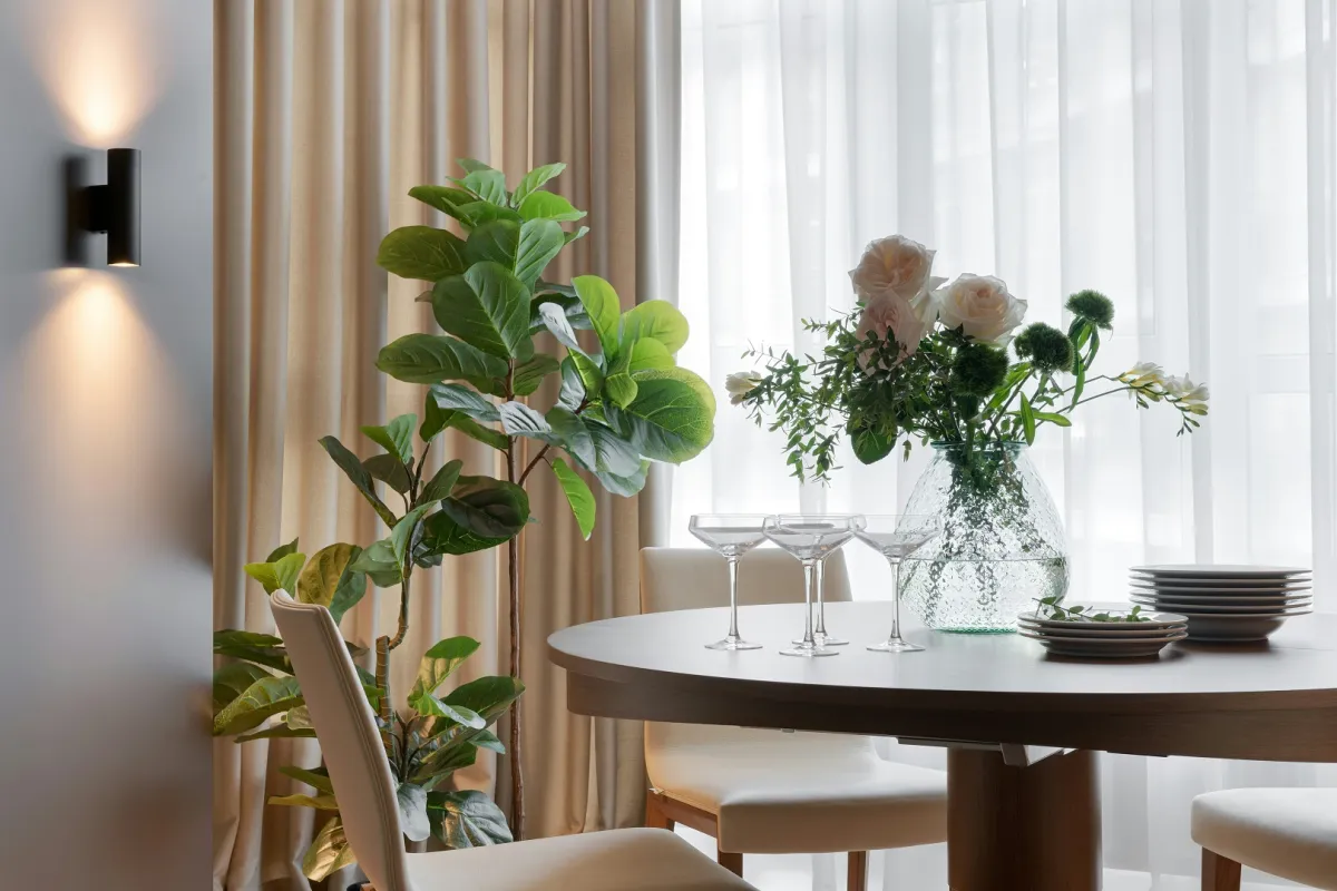 غرفة طعام مودرن مع إضاءة حائطية وزينة عبارة عن شجرة تين الكمان