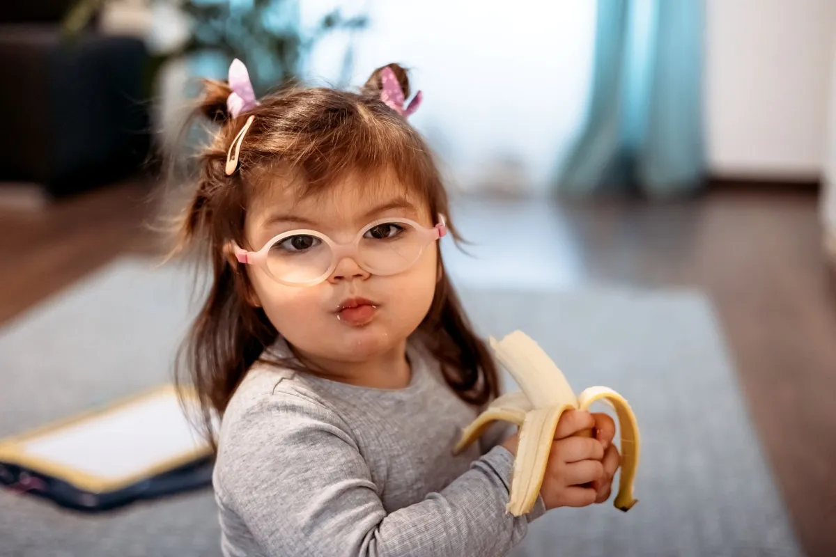 صورة طفلة تأكل موزة