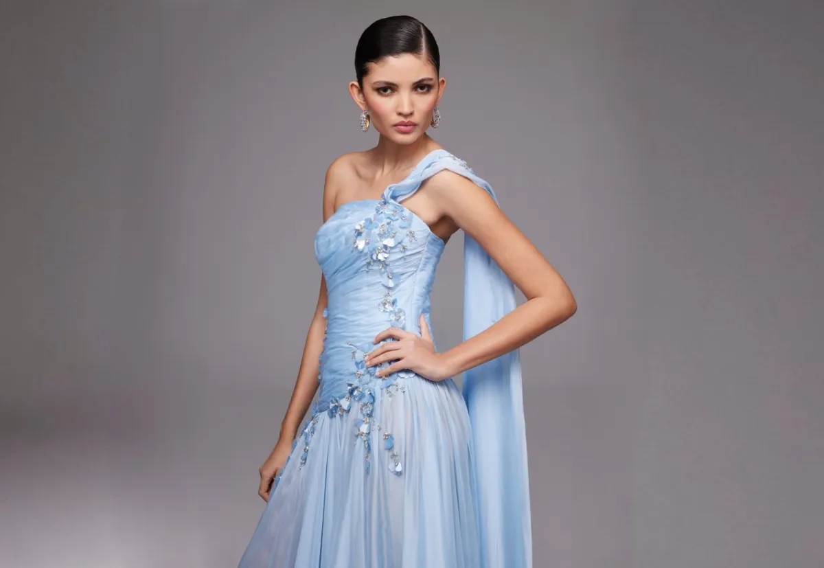 الفستان الأزرق المطرَّز باللؤلؤ والكريستال بقصة كتف واحدة -الصورة من نور الظاهري 