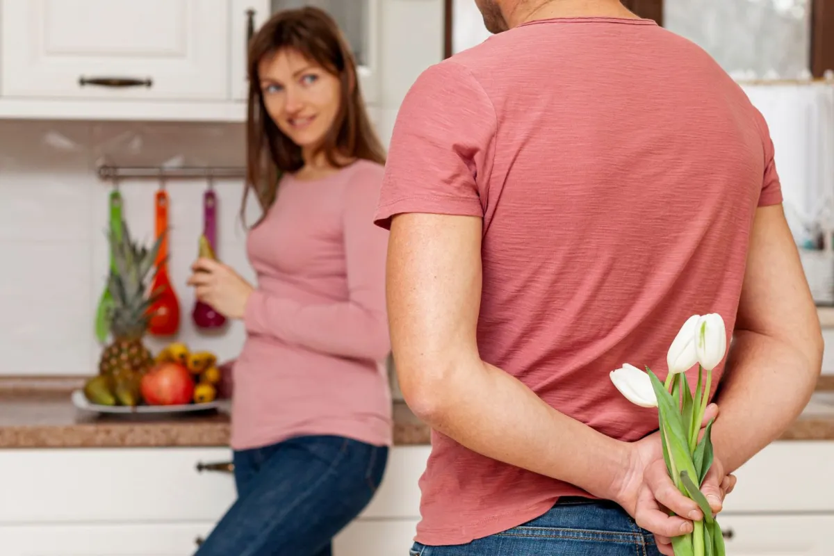 زوج يحمل زهوراً هدية لزوجته بعد عودته من السفر  