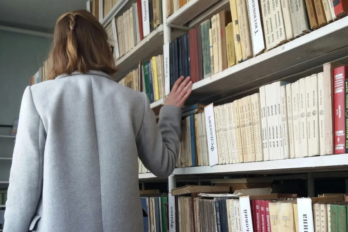 شابة تبحث عن كتاب في مكتبة 