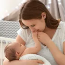  أم تقبل يد طفلها أثناء الرضاعة