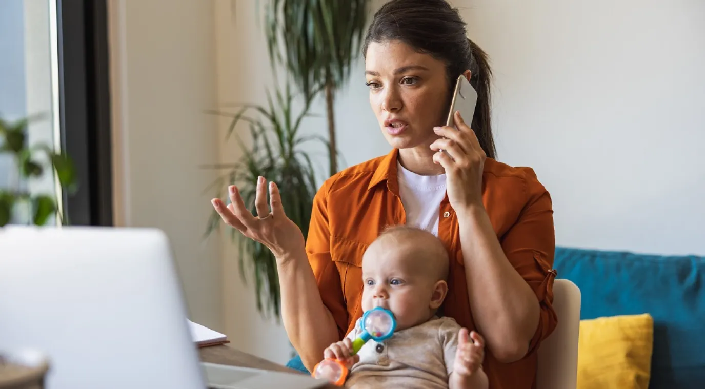 صورة لأم ترعى طفلها وهي تعمل