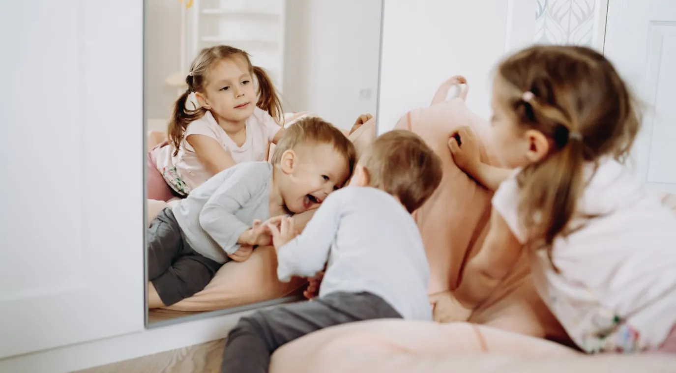 صورة أطفال يلعبون أمام المرآة