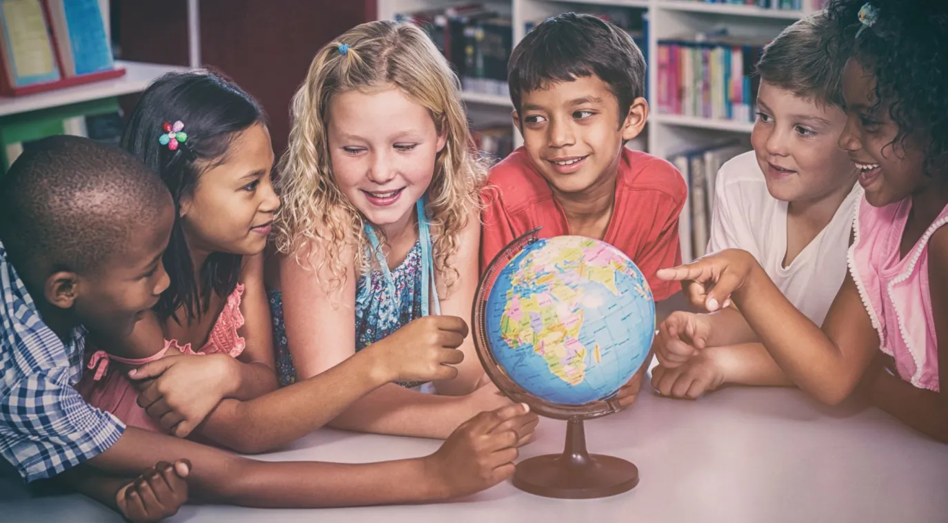 صورة أطفال يجتمعون حول الكرة الأرضية