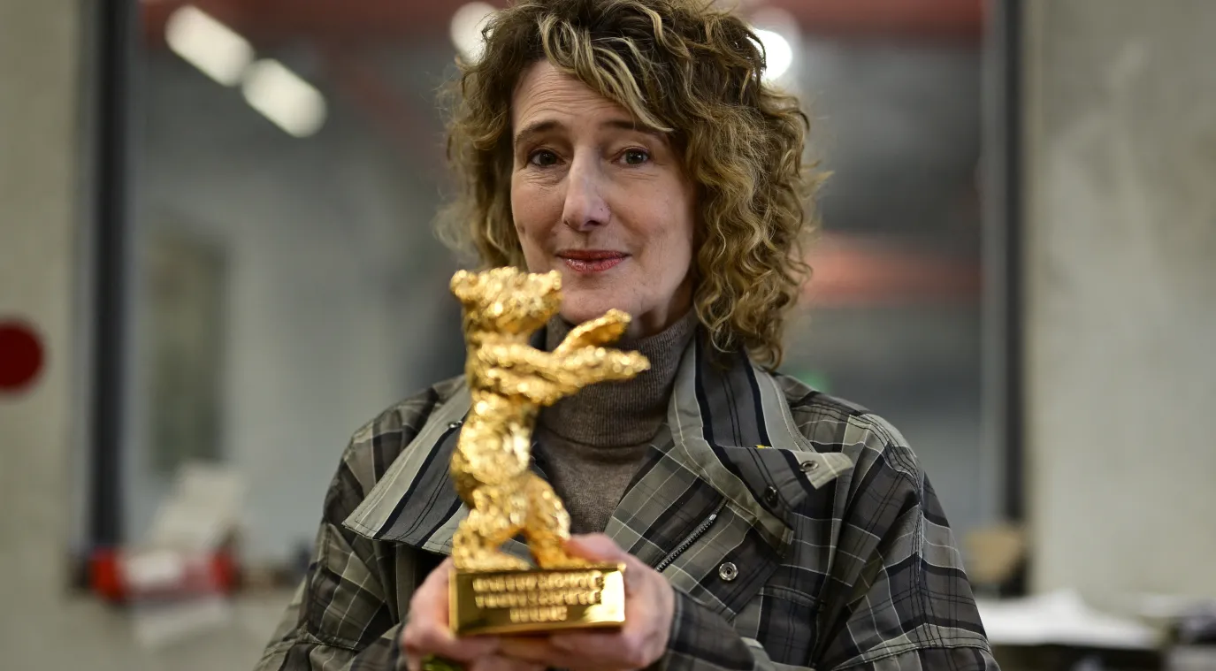 مديرة مهرجان برلين السينمائي الدولي، تريشيا تاتل، وهي تحمل جائزة «الدب الذهبي» - مصدر الصورة  AFP