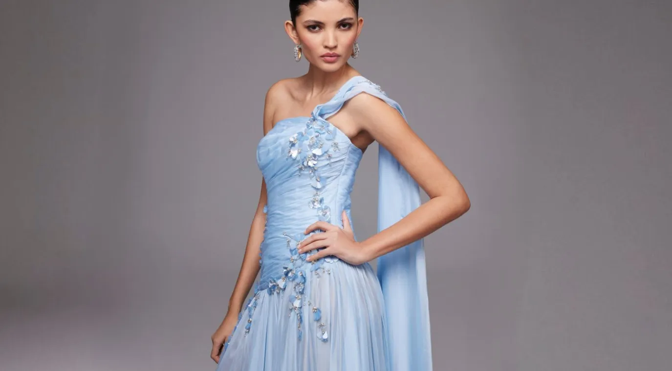 الفستان الأزرق المطرَّز باللؤلؤ والكريستال بقصة كتف واحدة -الصورة من نور الظاهري 