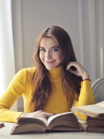 شابة تقرأ عدداً من الكتب في إدارة الأعمال والقيادة 