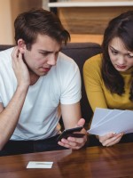 زوجان يناقشان مشالكهما المالية بغرض الوصول لطريقة لحلها