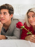 زوجة تهدي زوجها زهرة حمراء وتنظر له علامة على فهمه وهو يحاول أن يبدو متجاهلاً