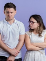 زوجة تنظر لزوجها المتهور بضيق وعتاب وهو ينظر للأمام بتأنيب ضمير