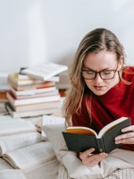 شابة تقرأ مجموعة من كتب السيرة الذاتية 