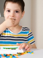 صورة لطفل يضع المكعب بفمه