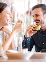 زوجان يتناولان الطعام سوياً بسعادة