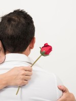 زوجة تحتضن زوجها وتمسك بيدها وردة زهرة حمراء 