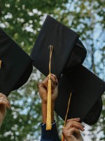 مجموعة من الخريجين يرفعون قبعة التخرج لاعلى 