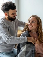 زوج يغطي كتفي زوجته بوشاح لتدفئتها  علامة على اهتمامه بها 