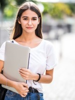 طالبة جامعية تحمل جهاز اللاب توب الخاص بها- الصورة من magnific