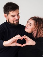 خطيبان يكونان معاً بيديهما شكل قلب ويبتسمان بسعادة   
