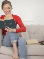 شابة تقرأ كتابا باستمتاع