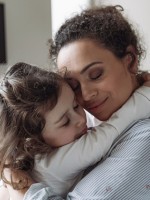 صورة أم تحتضن طفلتها