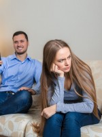 زوج يستمتع بوقته في مشاهدة التلفزيون والزوجة تبدو متضايقة من انشغال زوجها   
