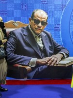 زوار يمرون بجوار ملصق يصور الكاتب المصري الراحل نجيب محفوظ