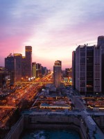 مشهد بانورامي خلّاب لأفق مدينة بكين العمراني عند الغسق، حيث تتألق أضواء المدينة النابضة بالحياة وتتلوّن السماء بألوانٍ زاهية.