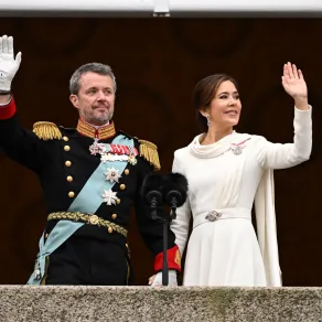 الملكة ماري والملك فريدريك- Queen Mary and King Frederik (مصدر الصورة: Jonathan NACKSTRAND / AFP) الملكة ماري ترتدي فستانا أبيض اللون وتقف بجوار زوجها على شرفة القصر لتحية الجماهير