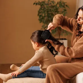صورة أم تمشط شعر ابنتها