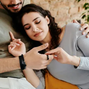 زوجة تتلمس بيدها أصابع زوجها برقة وتقضي وقتاً ممتعاً معه 