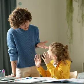 صورة معلمة تكلم طفلة