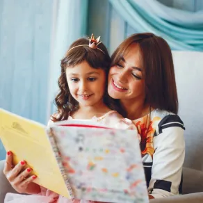 أم تقرأ لطفلتها  لتحفزها على السلوك الطيب صورة لأم تقرأ لطفلتها