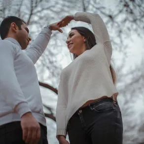 خطيبان يرقصان بسعادة ويرفعان أيديهما المتشابكة