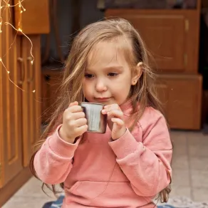 صورة لطفلة تشرب مشروباً منزلياً مهديئاً للسعال صورة لطفلة تشرب مشروباً منزلياً مهديئاً للسعال