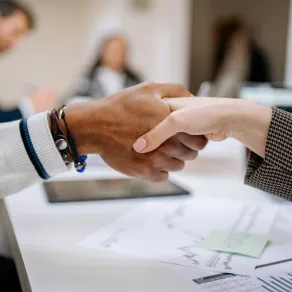 العمل بنزاهة يمنح الآخرين ثقة كبيرة، ويجعل كلمتك ذات مصداقية بالنسبة لهم أحد العملاء يسلم على موظف يتسم بالنزاهة