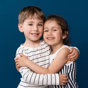 أخ وأخت يحتضنان بعضهما بحب ومودة صورة تعبرعن الأخوة