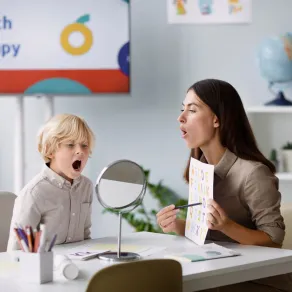 صورة لطفل لديه تأخر في النطق مع أخصائية نطق