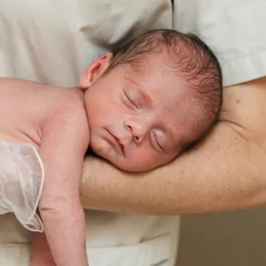 صورة ممرضة تحمل المولود