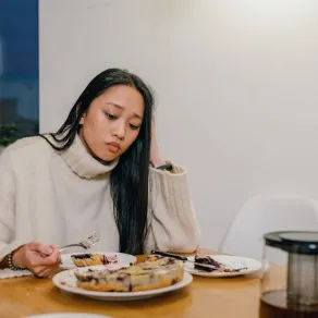 امرأة تشعر بالتوتر بعد تناول الطعام- المصدر: Pexels