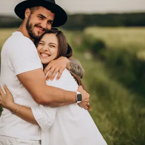 زوج يحتضن زوجته بحنان ومحبة وهي تبتسم بسعادة بين أحضان الطبيعة حيث إن الأمان في العلاقة الزوجية أساسي لأنه يبني الثقة، ويعمق الروابط العاطفية - المصدر: freepik زوج يحتضن زوجته بحنان ومحبة وهي تبتسم بسعادة بين أحضان الطبيعة