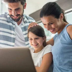 صورة لطفلة ووالديها أمام الجهاز