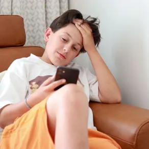 صورة مراهق مدمن على الهاتف