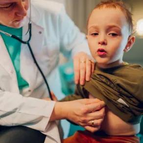 يوجد أعراض مرافقة للسعال تستدعي الذهاب بالطفل إلى الطبيب فوراً صورة طبيبة تفحص الطفل