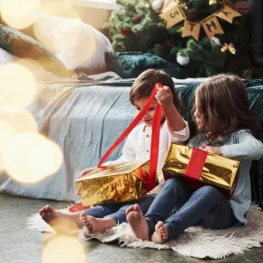 صورة لطفلين يفتحان الهدايا