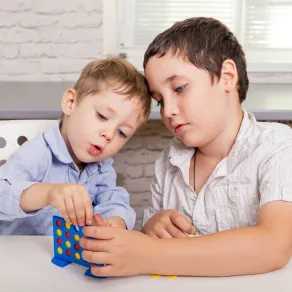 صورة طفلين يحاولان حل مشكلة لعبة