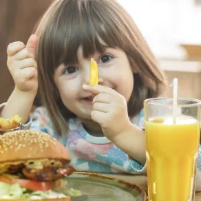 صورة لطفلة تأكل وجبة من البطاطس